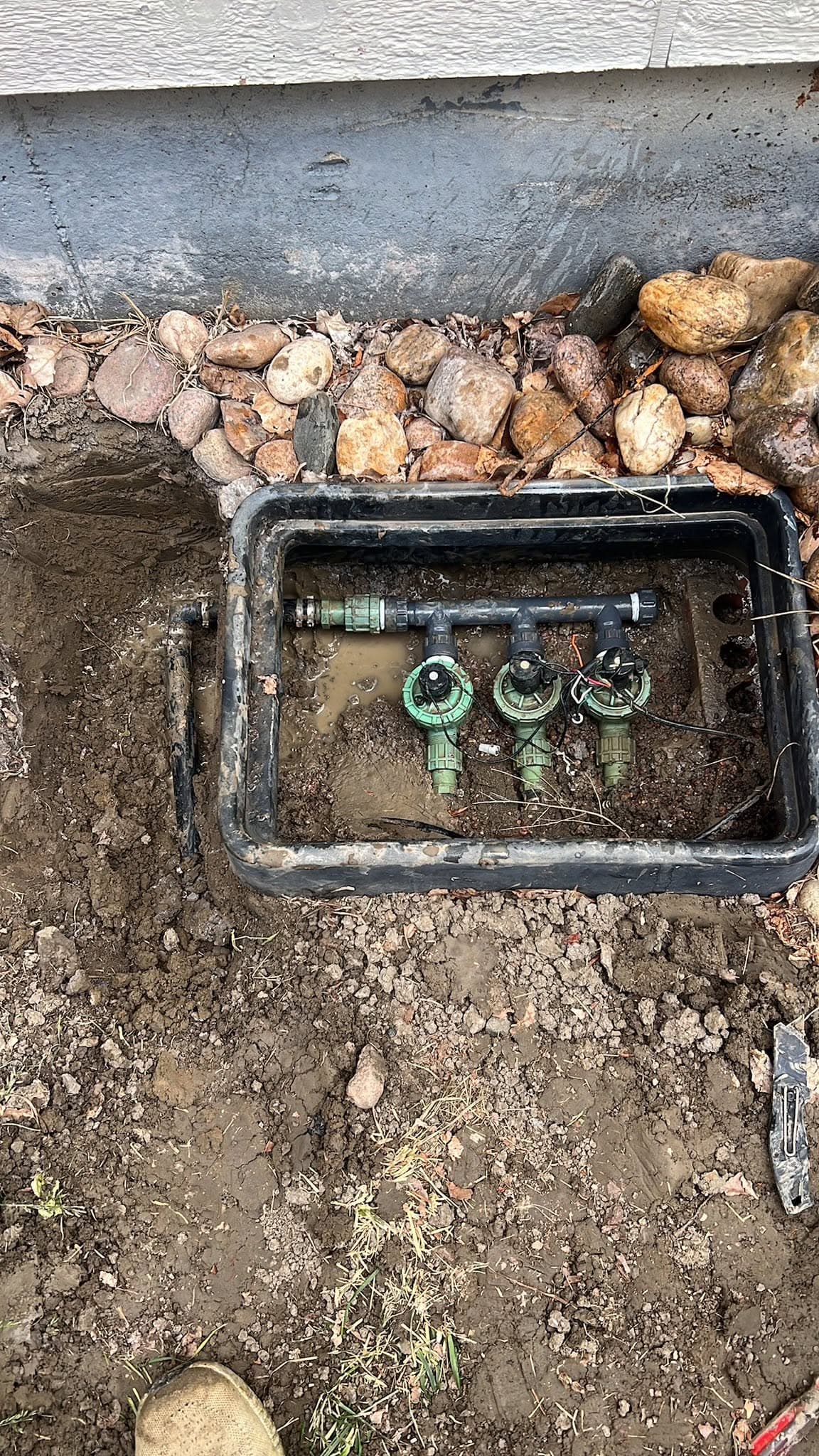 Underground water valve installation with metal fittings in an excavated pit
