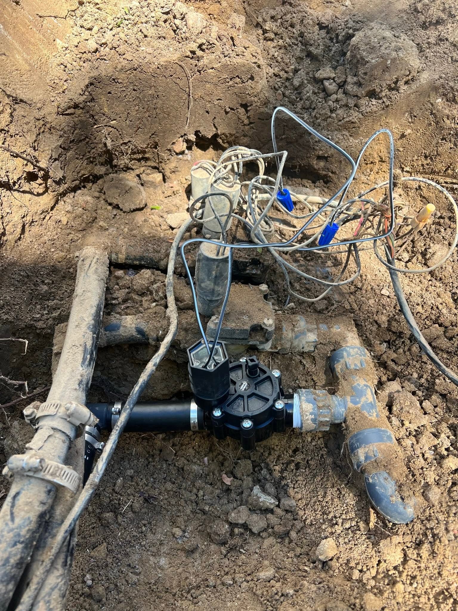 Underground irrigation pump system with connected pipes in a trench
